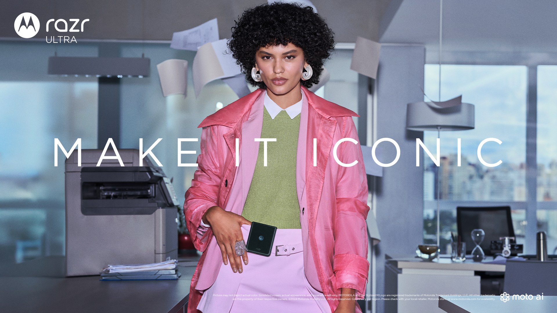 razr ultra key visual with "MAKE IT ICONIC" across a woman in pink holding a flip phone, papers flying